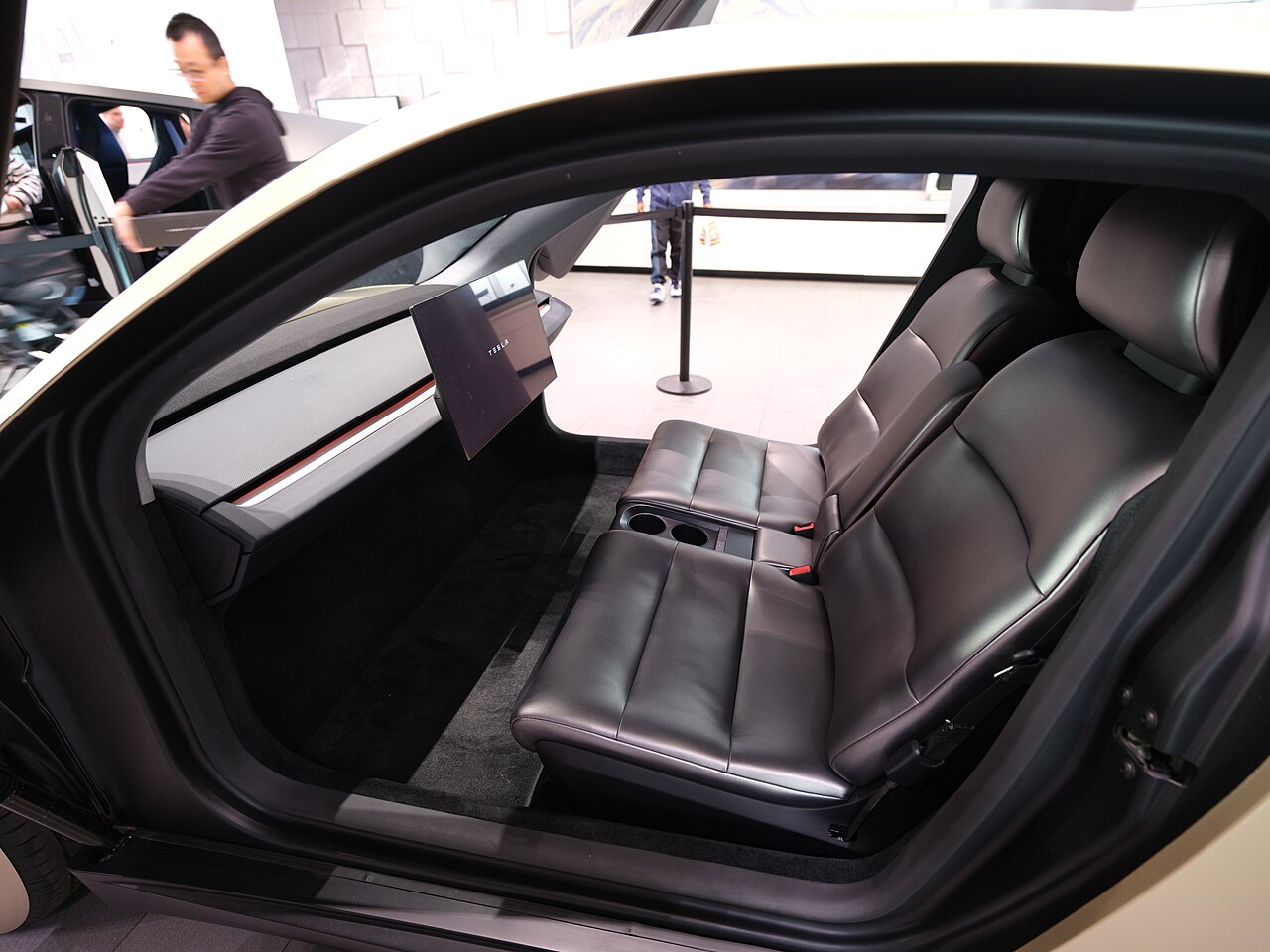 Tesla Cybercab cabin interior with large central touchscreen, two bench seats, and no steering wheel or pedals