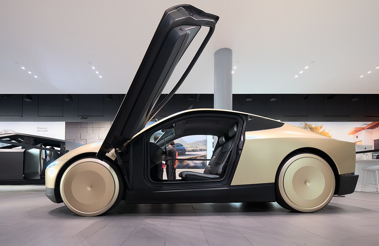 Tesla Cybercab side profile showing golden reaction-injection-molded body and aero wheel covers