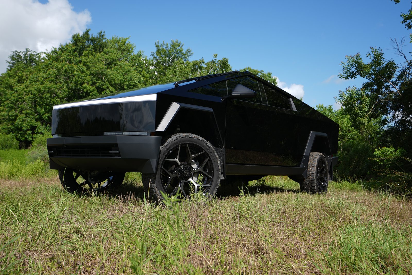 Gloss black Cybertruck front view in field