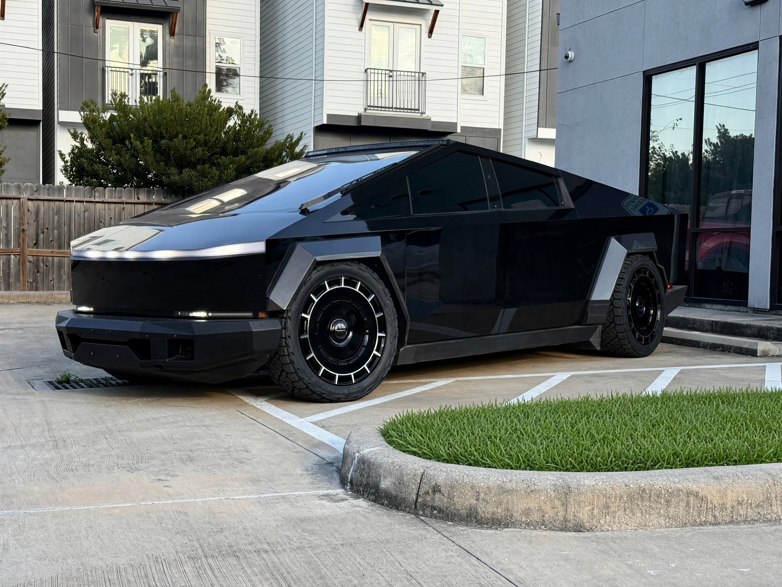 Gloss black Cybertruck with matte widebody flares, roof light bar and aero-disk wheels at EVS Motors