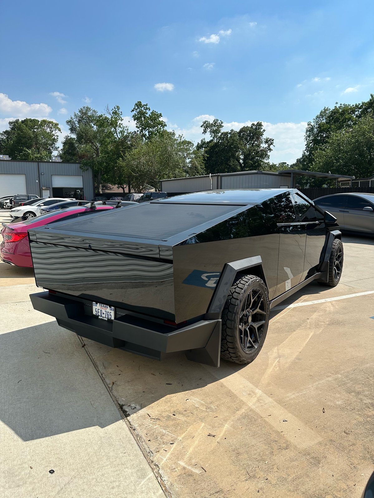 Gloss black Cybertruck rear in lot, plate 5E0-765