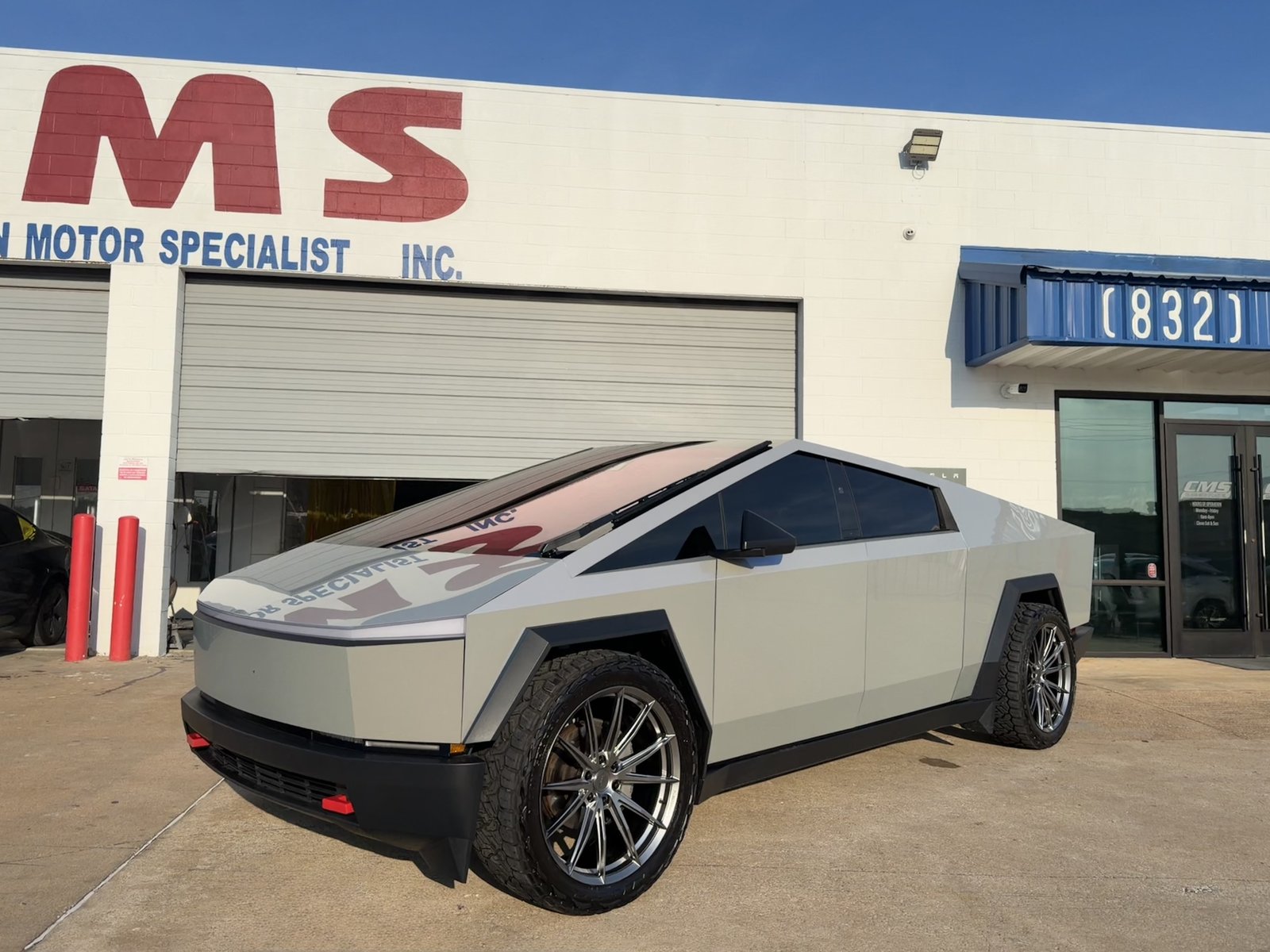 Light gray Cybertruck wrap with fender flares and red tow hooks