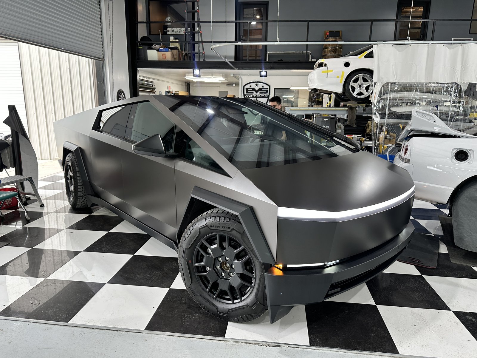 Matte black Cybertruck in shop with driver in seat