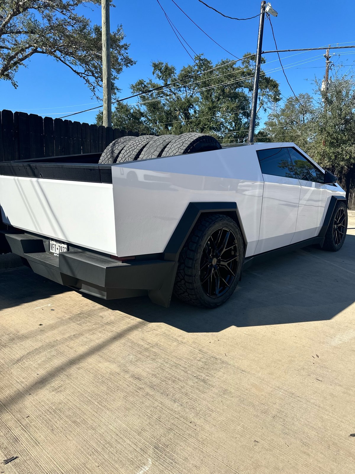 White Cybertruck with tires in bed, plate VFT-7977