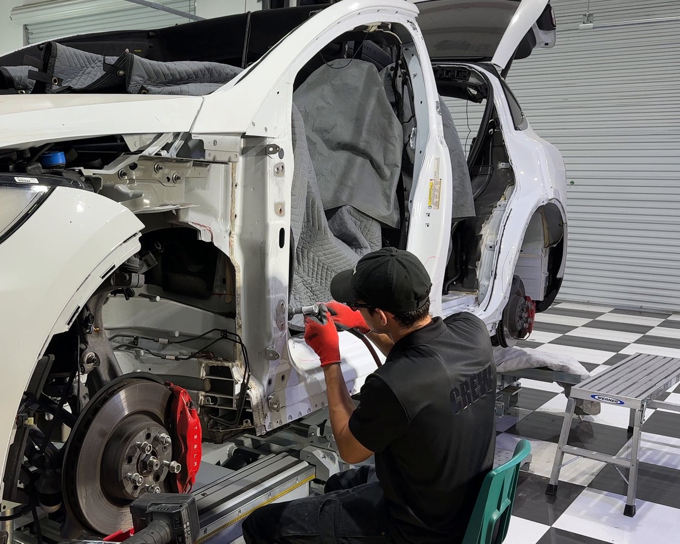 EVS Motors technician welding during a structural repair on a Tesla Model X
