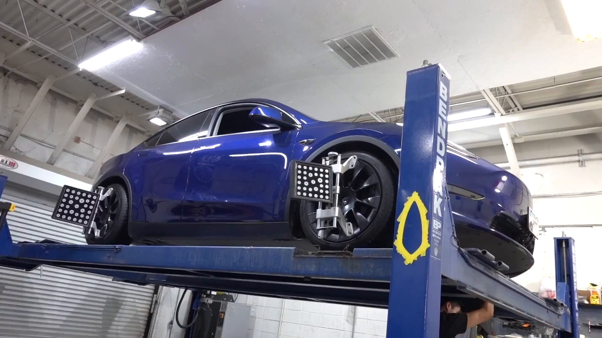 Tesla Model Y on the alignment lift at EVS Motors