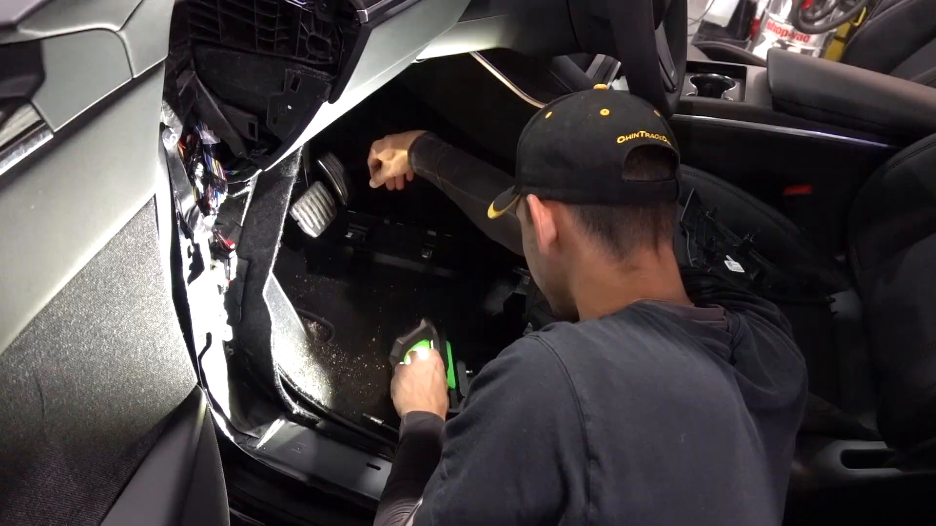 Technician routing audio wiring inside a Tesla Model X