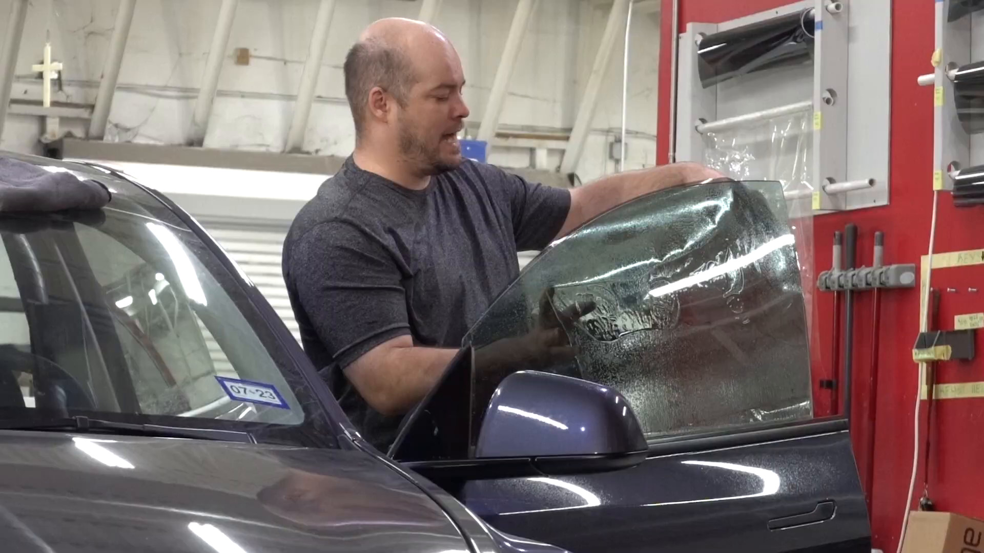 Window tint film being fitted to a rear window at EVS Motors